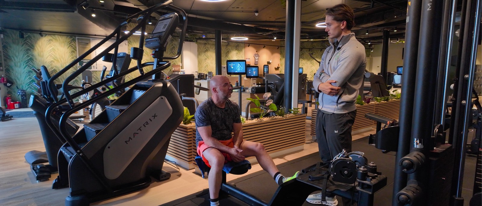 Coach en klant bespreken de voortgang in de sportschool